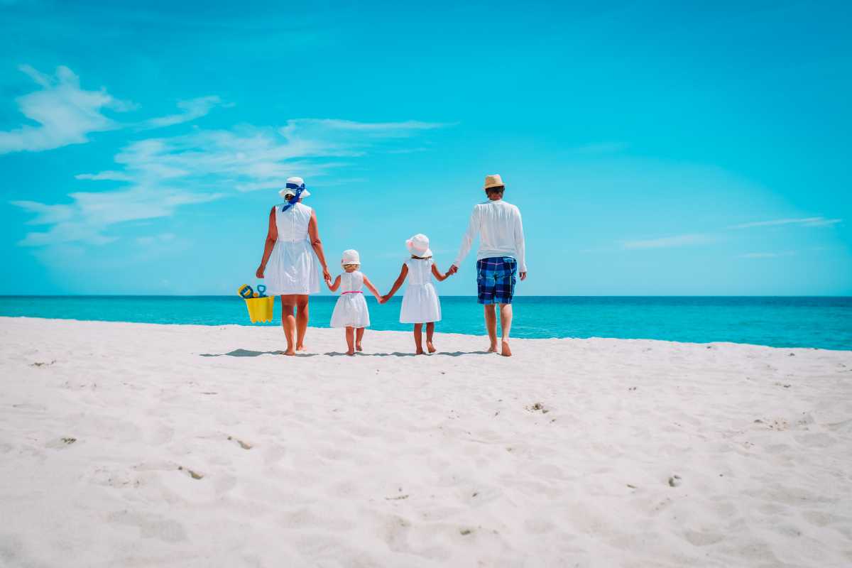 Spiaggia di Lignano Sabbiadoro con famiglie e bambini che giocano nella sabbia
